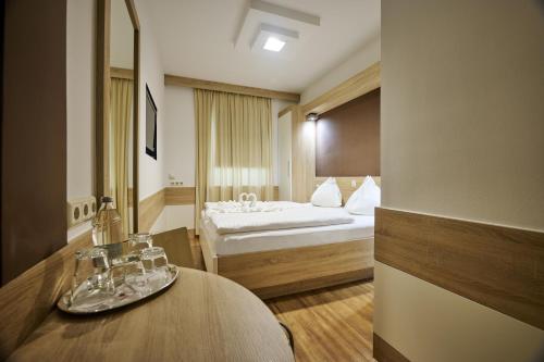 a hotel room with a large bed and a large mirror at Best Western Hotel Strasser in Graz