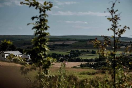 a view of a field with a house and trees at Grains Bar Hotel in Oldham