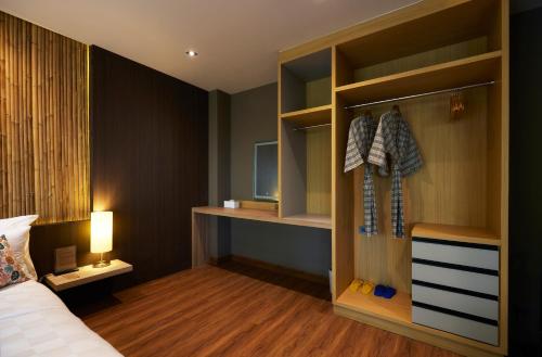 a hotel room with a bed and a closet at Sand Dollar Boutique Hotel in Bang Sare