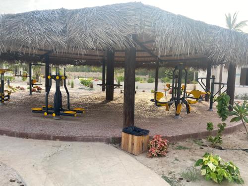 a gym with a straw roof and swings at Segal Salalah-Forest Island-Hawana in Salalah