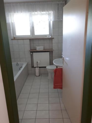 uma casa de banho com uma banheira, um WC e um lavatório. em Ferienwohnung Käthe em Sonsbeck