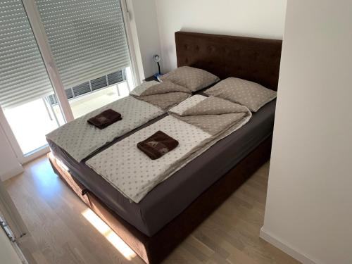 a bedroom with a bed with two pillows on it at Apartman Jasmin - Blizu Panonskih jezera i centra grada in Tuzla