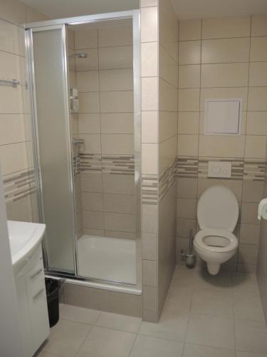 a bathroom with a toilet and a glass shower at Hotel Garni VŠB TUO in Ostrava