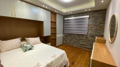 a bedroom with a bed and a brick wall at Royal Luxury Apartment with Gorgeous Sea View in Alexandria
