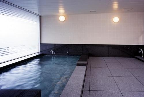 einen Pool in einem Gebäude mit einem großen Fenster in der Unterkunft ホテルルポール麹町 in Tokio