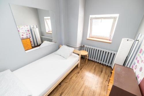 a small room with a bed and a mirror at Jopi Hostel Katowice Centrum in Katowice