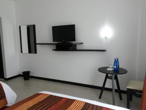 a room with a table and a tv on a wall at Hotel Osalle Inn in Chignahuapan
