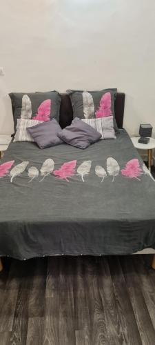 a bed with pink and white birds on it at Studio Rue Fesch - Vieille Ville in Ajaccio