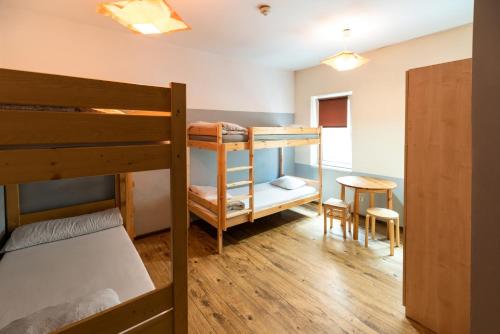 a dorm room with bunk beds and a table and a desk at Jopi Hostel Katowice Centrum in Katowice