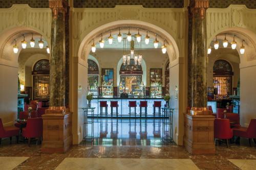a bar in a building with red chairs at Grand Hotel Europe, A Belmond Hotel, St Petersburg in Saint Petersburg