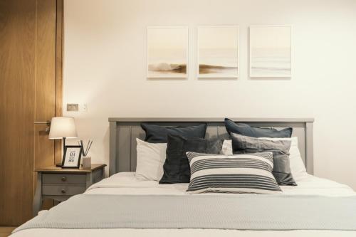 a bedroom with a bed with black and white pillows at Sandbox beachfront villa2 in Bang Lamung
