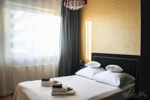 a bedroom with a bed with towels on it at D Apartments Centrum Jurowiecka III in Białystok