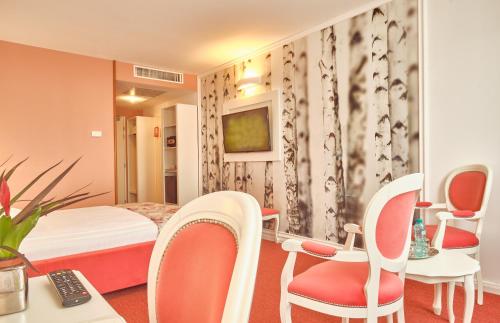 a hotel room with a bed and a table and chairs at Continental Forum Bucuresti Palatul Parlamentului in Bucharest
