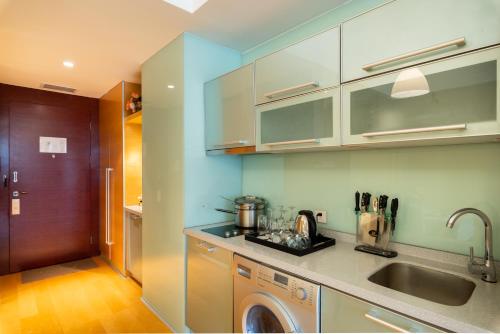 a kitchen with a washing machine and a sink at Tianjin Crown International Apartment in Tianjin