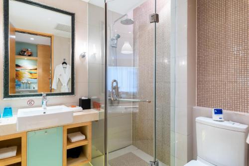 a bathroom with a shower and a sink and a toilet at Tianjin Crown International Apartment in Tianjin