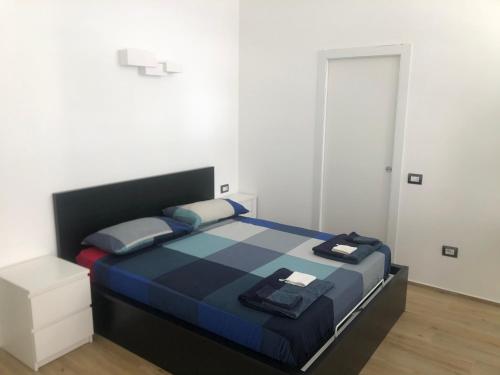 een slaapkamer met een bed in een witte kamer bij Loft Eleonora D’Arborea in Quartu SantʼElena