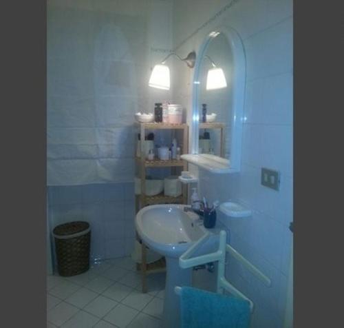 Baño blanco con lavabo y espejo en Vomero District Apartment, en Nápoles