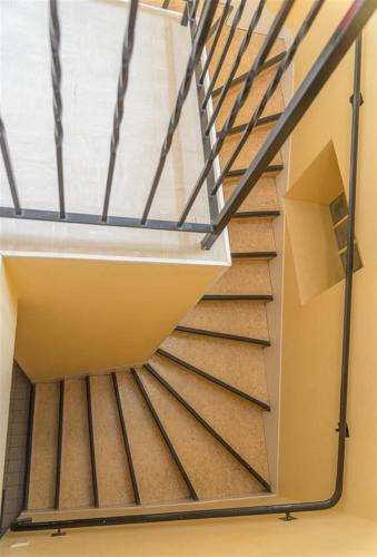 a staircase in a building with a metal railing at HOTEL DU CYGNE DE LA CROIX BLANCHE in Lailly-en-Val