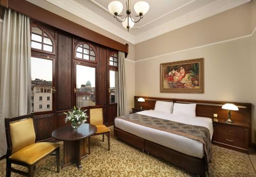 a hotel room with a bed and a table and chairs at Legacy Ottoman Hotel Istanbul Old City in Istanbul