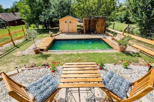 a small pool in a yard with two chairs at AgroPing Korosajt Műhely in Nemesbük