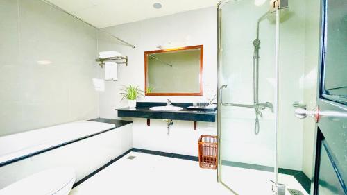 a bathroom with a shower and a sink at Sea Pearl Cat Ba Hotel in Cat Ba