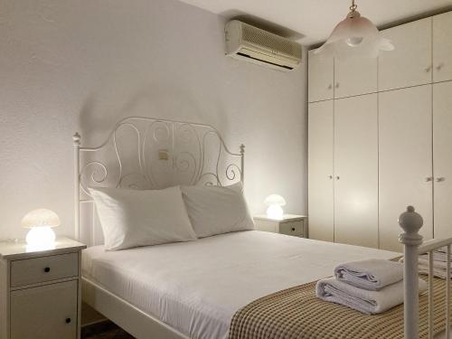 1 dormitorio blanco con 1 cama con cabecero blanco en Sanny's Place, en Kavala
