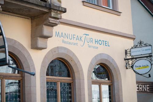 a building with a sign on the side of it at Manufaktur Boutique Hotel in Stadt Wehlen