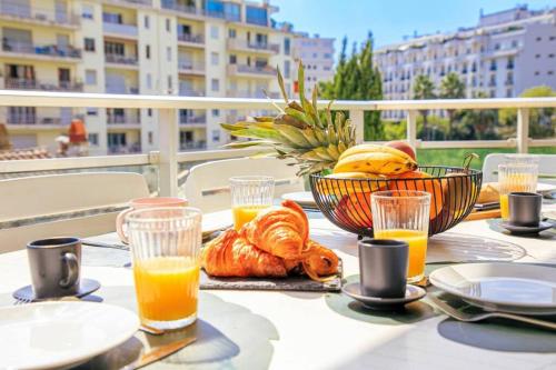 une table avec de la nourriture et des verres de jus d'orange dans l'établissement Le Bain De Soleil - Le Bain De Soleil 5 star Two bedroom apartment, à Cannes