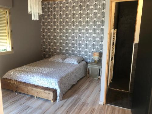 une chambre avec un lit et un mur dans l'établissement Le Montagnon, à Lupé
