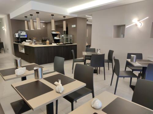 ein Restaurant mit Tischen und Stühlen und einer Theke in der Unterkunft Hotel Emiliana in Villadossola