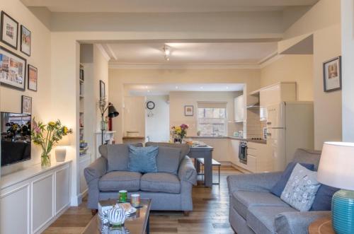 a living room with two couches and a kitchen at 109 Nunnery Lane - a House of York holiday home in York