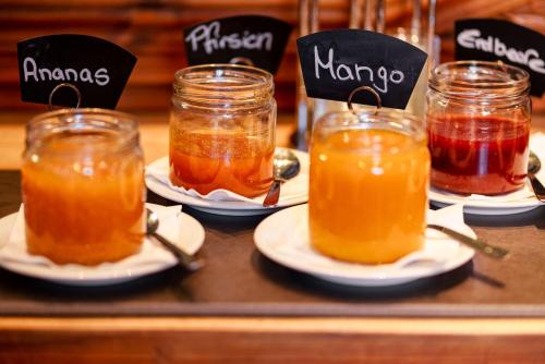 a tray with three jars of honey and plates of jam at Manufaktur Boutique Hotel in Stadt Wehlen