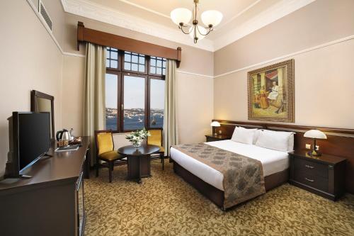 a hotel room with a bed and a television at Legacy Ottoman Hotel Istanbul Old City in Istanbul