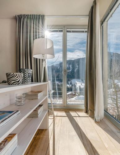 a living room with a floor lamp and a large window at Picenin 61 Lodging in La Villa