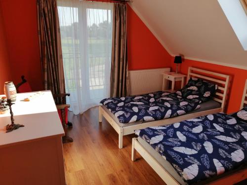 dwa łóżka w pokoju z pomarańczowymi ścianami w obiekcie Apartament Mysłakowice w mieście Mysłakowice
