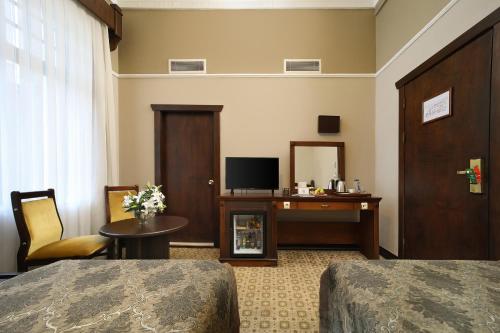 a hotel room with two beds and a table and a television at Legacy Ottoman Hotel Istanbul Old City in Istanbul