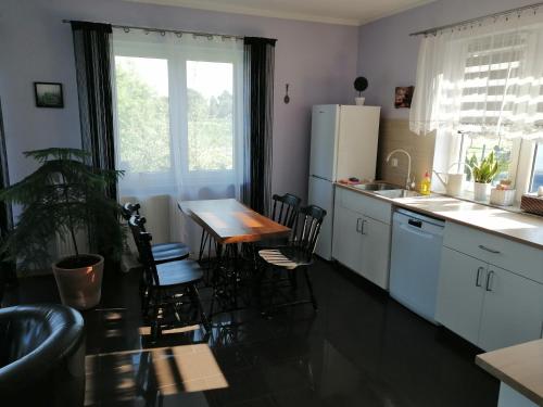 a kitchen with a table and chairs and a refrigerator at Apartament Mysłakowice in Mysłakowice