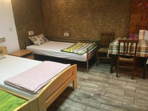 Habitación con 2 camas, mesa y escritorio. en Casa Roz en Cluj-Napoca