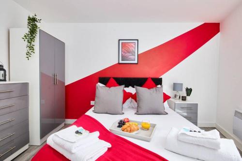 - une chambre rouge et blanche avec un lit et un plateau de nourriture dans l'établissement Perfect City-Break Apartment with Free Private Parking by HASS HAUS, à Manchester