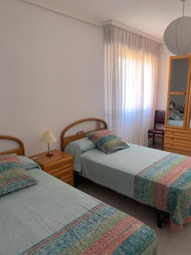 a hotel room with two beds and a mirror at La Cabañita de Leiva in Leiva