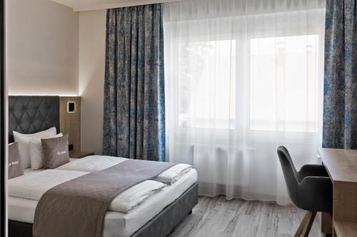 um quarto com uma cama e uma grande janela em Restaurant & Hotel Dabuki em Neutal