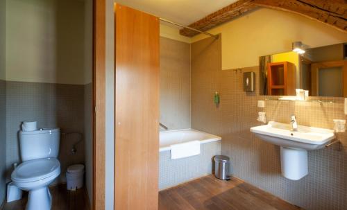 a bathroom with a toilet and a sink and a tub at Hotel The Lodge Heverlee in Leuven