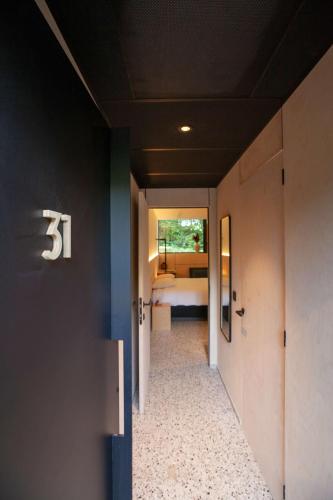 a hallway leading to a bedroom with a bed at Hotel The Lodge Heverlee in Leuven