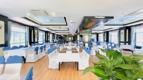 a banquet hall with white tables and blue chairs at Sea Pearl Cat Ba Hotel in Cat Ba