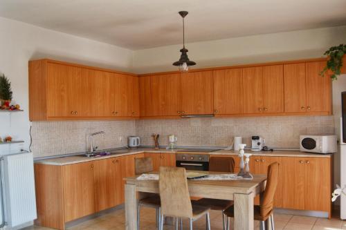 a kitchen with wooden cabinets and a table with chairs at Fully renovated apartment-ανακαινισμένο διαμέρισμα in Paradeísion