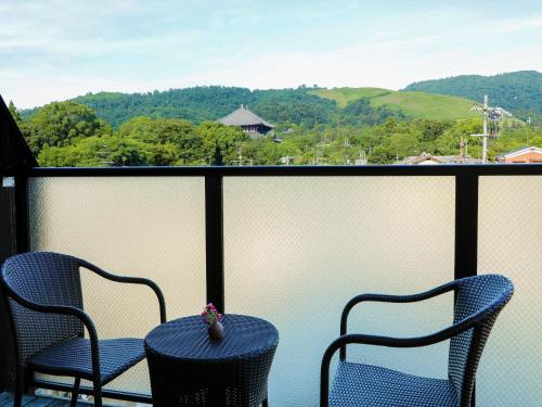 two chairs and a table on a balcony with a view at Wakasa Annex in Nara