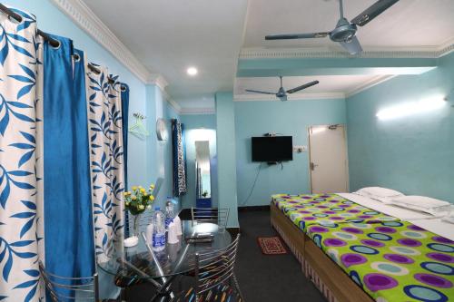 a bedroom with a bed and a table and a television at Hotel Airways in Kolkata