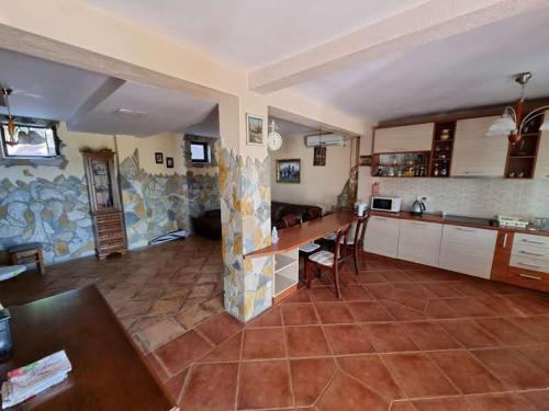 a large kitchen with a table and chairs in a room at Дом для семейного отдыха в Утехе, Черногория in Utjeha