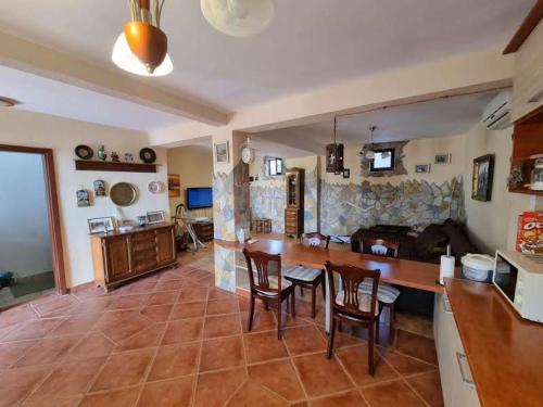 a kitchen and living room with a table and chairs at Дом для семейного отдыха в Утехе, Черногория in Utjeha