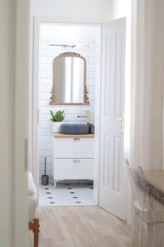 a white bathroom with a sink and a mirror at Lechner4 Residence in Szeged